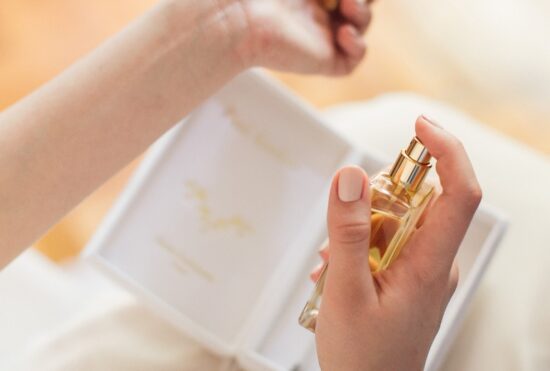 Mariée en train de se parfumer le poignet avec un parfum Galimard au flacon doré