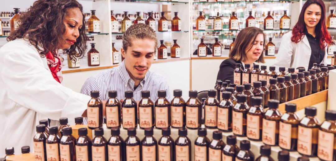 Une femme (nez parfumeur) aidant mister PACA 2024 en train de réaliser son parfum personnalisé dans le studio de fragrances Galimard à Grasse sur la Côte d'Azur