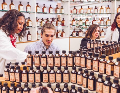 Une femme (nez parfumeur) aidant mister PACA 2024 en train de réaliser son parfum personnalisé dans le studio de fragrances Galimard à Grasse sur la Côte d'Azur