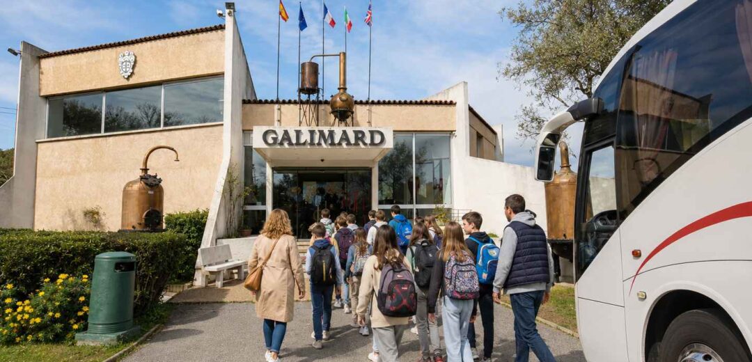 Groupe d’élèves accompagnés de leurs encadrants se dirigeant vers l’entrée de l’Usine-Musée de la Maison de Parfums Galimard à Grasse, après leur arrivée en car scolaire.